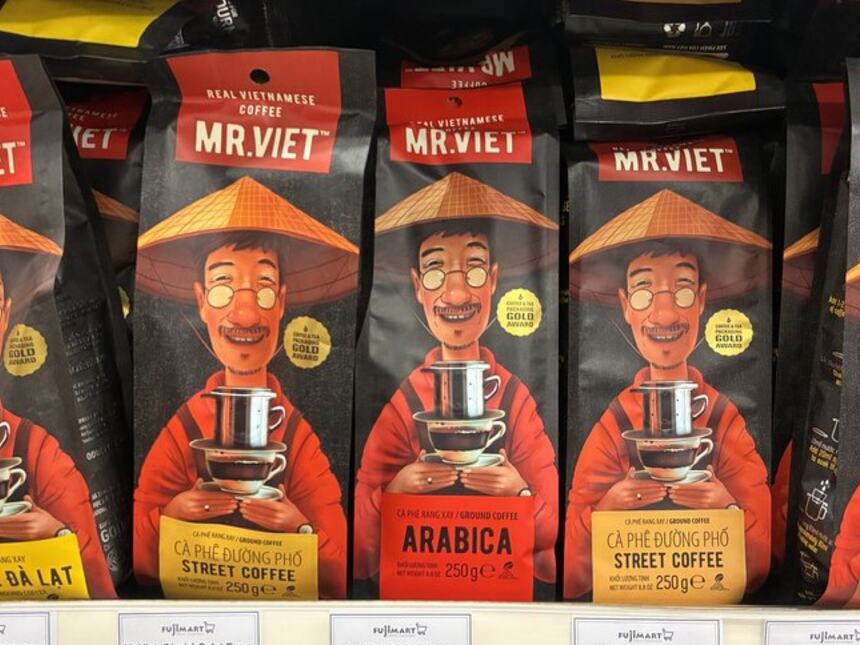ノンラーをかぶった男性のイラストが目印のMR.VIETの挽き粉250g袋。FujiMartの棚に187,000〜234,000ドンの値札が並ぶ。