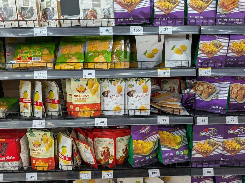 ベトナムのスーパーのドライフルーツ売り場に並ぶ複数ブランドの袋と値札