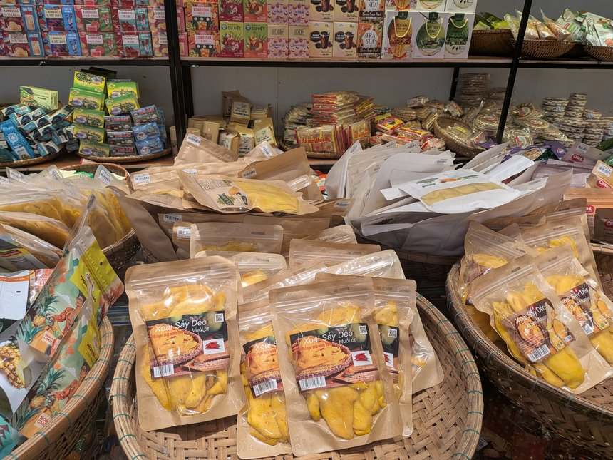 ベトナムのお土産店の平台に積まれたクラフト袋入りのドライマンゴー