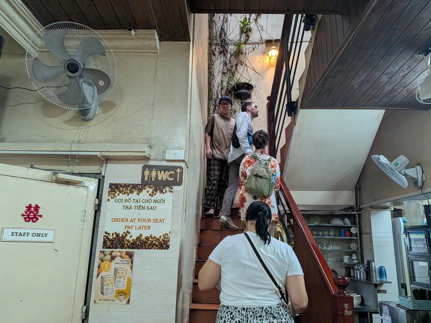 Cafe Giảngの2階へ上がる急な階段。観光客が列になって上がっている。