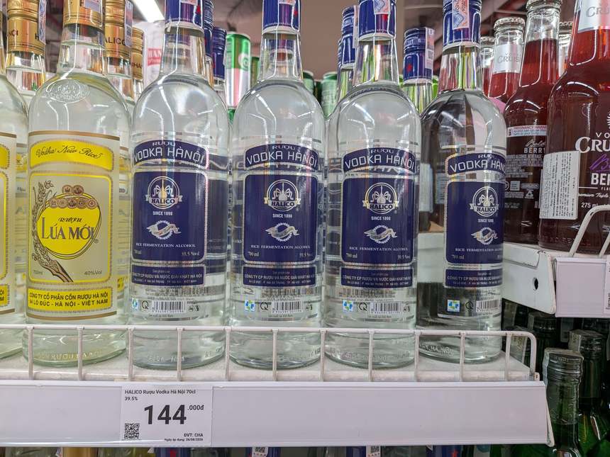 ベトナムのルアモイ700ml 40%volと、隣に並ぶウォッカハノイ70cl 39.5%の値札144,000ドン