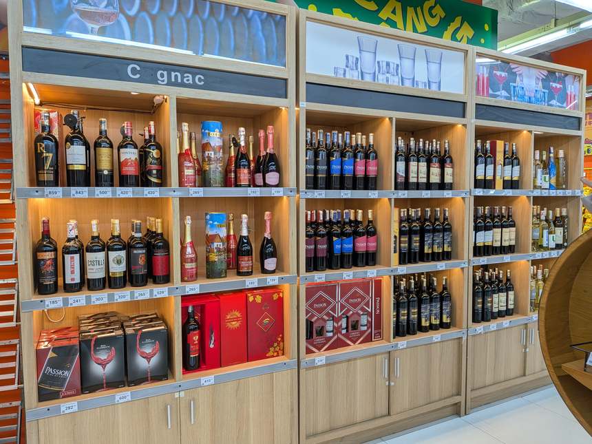 ベトナムのスーパーのお酒売り場。ワインとコニャックの棚に値札が並ぶ