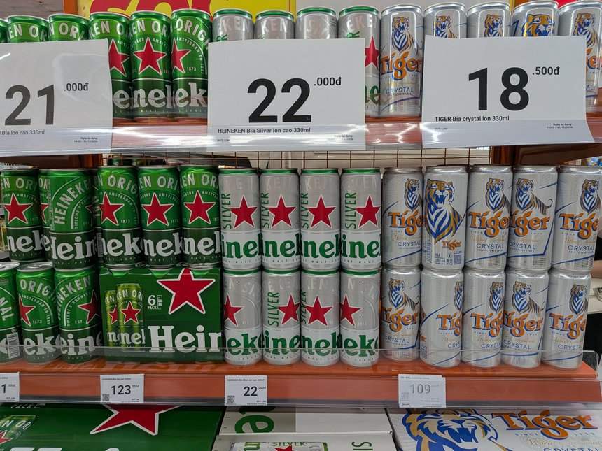 ベトナムのスーパーのビール売り場。330ml缶の値札が18,500ドン、21,000ドン、22,000ドンと並ぶ