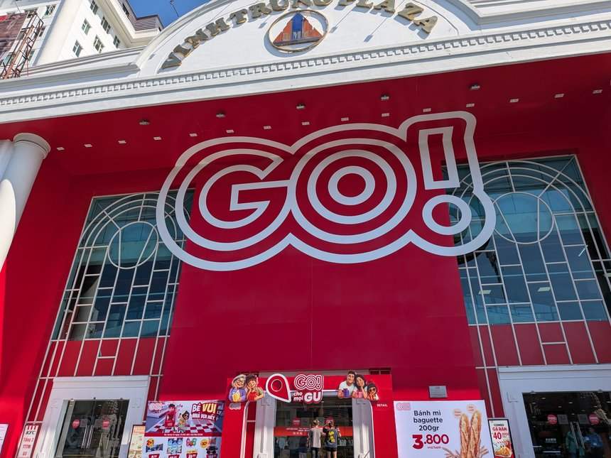 ベトナムの大型スーパーGO!の外観。赤い壁面に白いロゴが入り、入口前に販促の看板が並ぶ