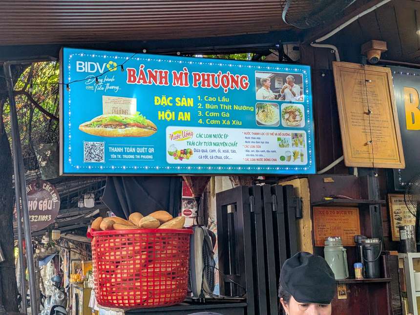 バインミーフーンの店頭にある、QR決済とホイアン名物料理を案内する青い看板
