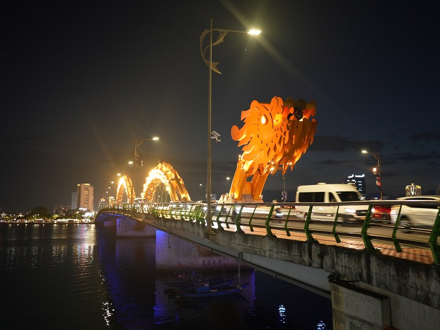 夜のドラゴンブリッジの全景。龍の胴体がアーチ状に光り、車道を車が走っている