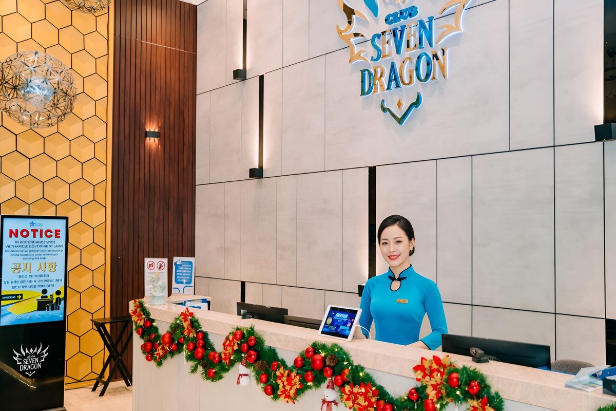 Friendly staff welcoming guests at the front desk of Club Seven Dragon casino in Da Nang.