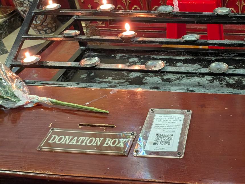 ハノイ大教会の中のろうそく立てと、DONATION BOXと書かれた献金箱。横に銀行振込用のQRコードの案内