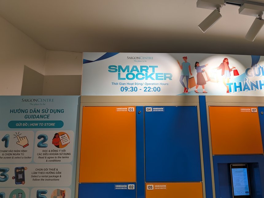 サイゴンセンターB1のスマートロッカー。オレンジと青の扉と、利用時間9:30〜22:00の表示