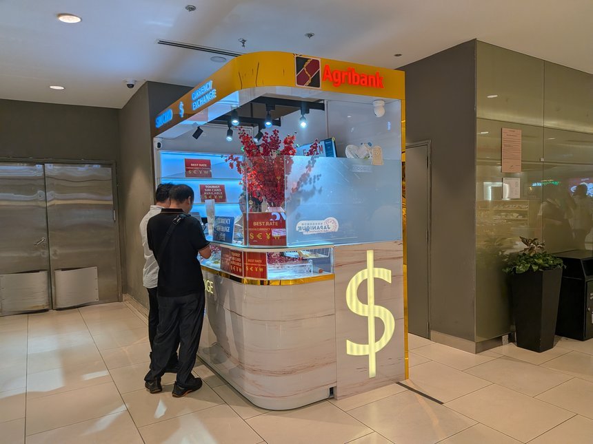 ホーチミン高島屋B2にあるAgribank公式代理店の両替ブース。ドルのマークが光る窓口で手続きする客
