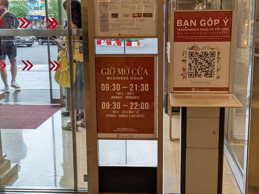 ホーチミン高島屋の入口に置かれた営業時間の案内。月〜木9:30〜21:30、金〜日・祝日9:30〜22:00