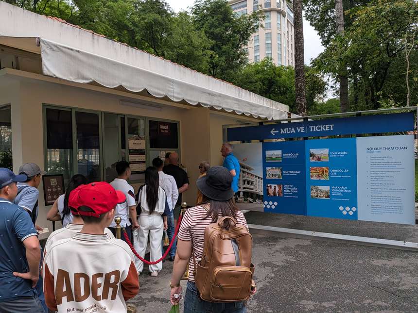統一会堂のグエンズー通り側のチケット売り場。窓口に旅行者が並び、横に「MUA VÉ｜TICKET」の青い案内板が立つ