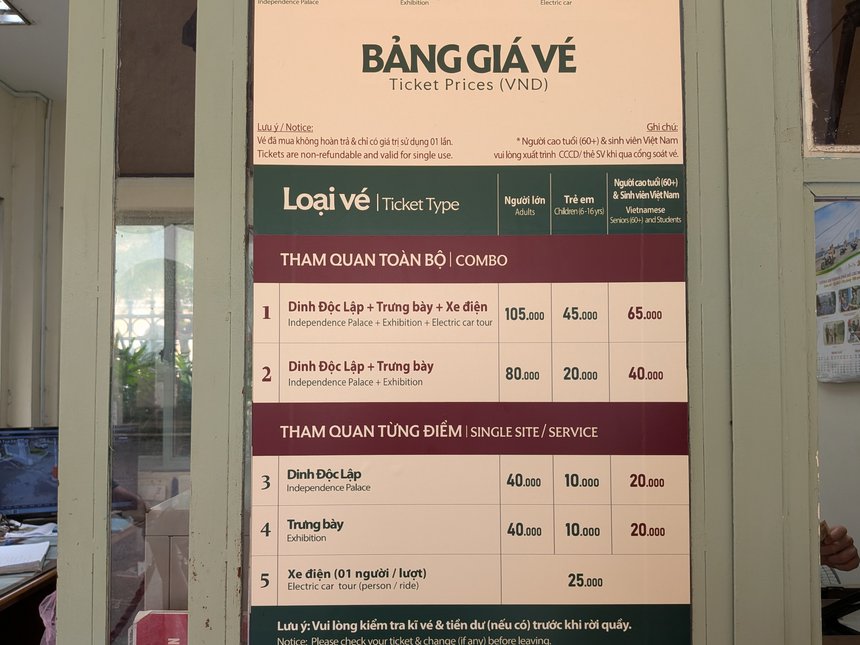 統一会堂のチケット窓口に貼られた料金表「BẢNG GIÁ VÉ」。セット券2種類と、本館・展示館・電気カーの単独の料金が並ぶ