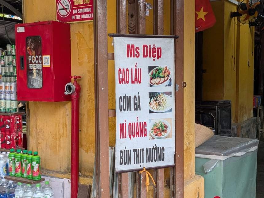 ホイアン市場の食堂「Ms Diệp」の看板。CAO LẦU、CƠM GÀ、MÌ QUẢNG、BÚN THỊT NƯỚNGの文字