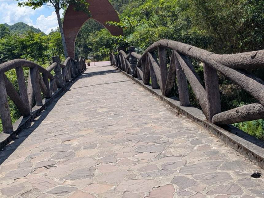 ミーソン遺跡の園内にあるアーチ型のゲートと木の欄干の歩道橋