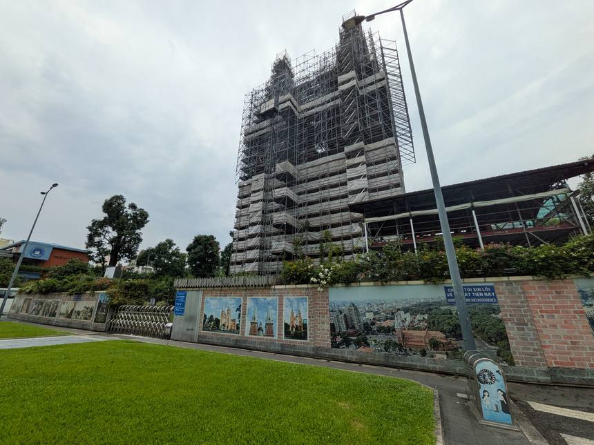 広場の芝生越しに見たサイゴン大教会。足場に覆われた建物と、手前に続く工事の囲い