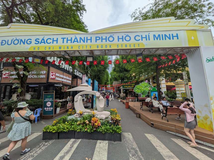 サイゴン中央郵便局の横にあるブックストリートの入口。「ĐƯỜNG SÁCH THÀNH PHỐ HỒ CHÍ MINH」の門の奥に書店と木のベンチが並ぶ