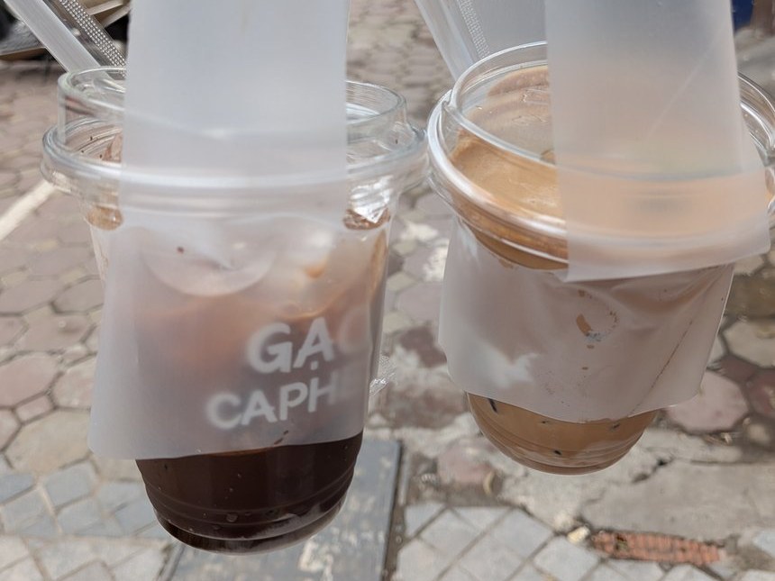 持ち帰り用のビニール袋に入った2杯のコーヒー。カップに「GẠO CAPHEE」の文字が入っている。