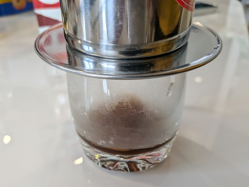 グラスに載せたフィン。湯を注いで待つ間に、グラスの底にコーヒーが落ち始めている