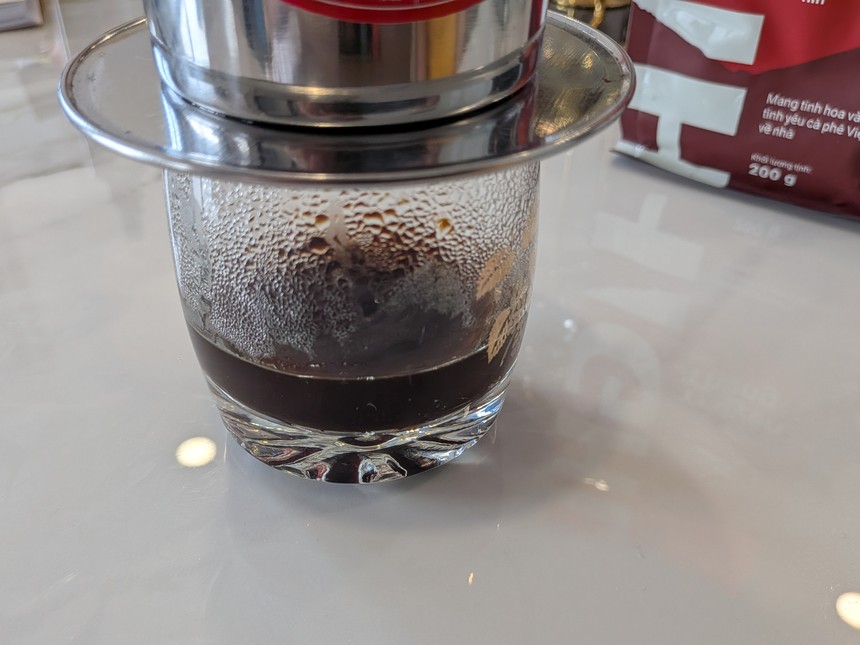 フィンから落ちたコーヒーがグラスにたまってきたところ。後ろにハイランズコーヒーの粉の袋