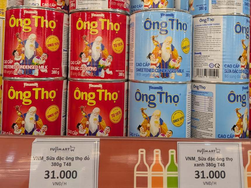 FujiMartの練乳の棚。ビナミルクのÔng Thọ 380g缶が並び、赤と青の缶に31,000ドンの値札が付いている