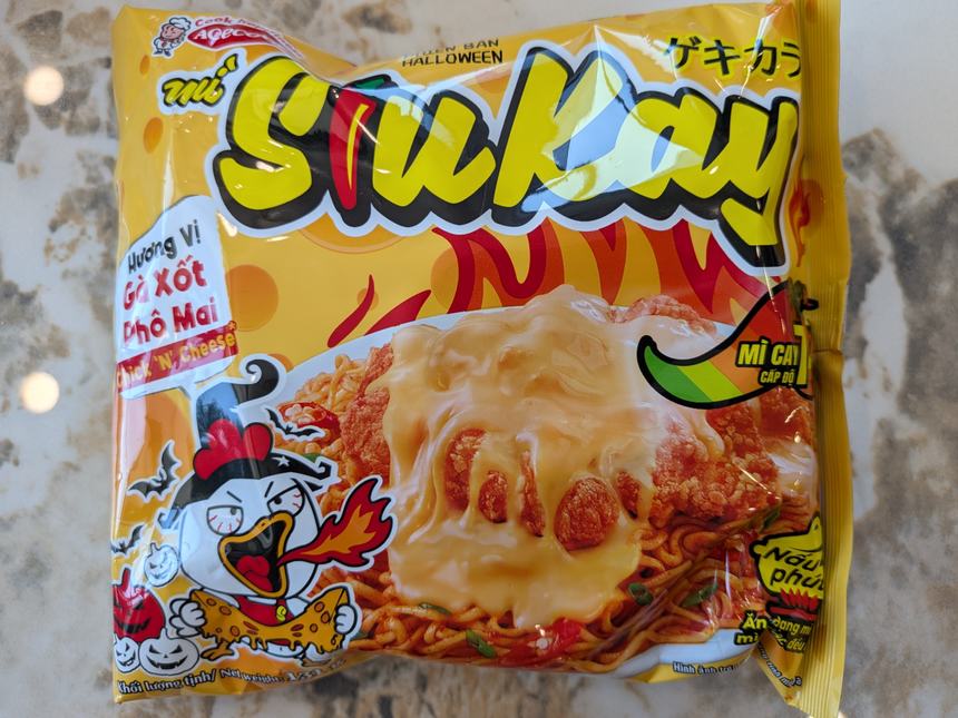 SiuKayのチーズソース味インスタント麺。黄色いパッケージにハロウィン仕様の鶏のキャラクターが描かれている。
