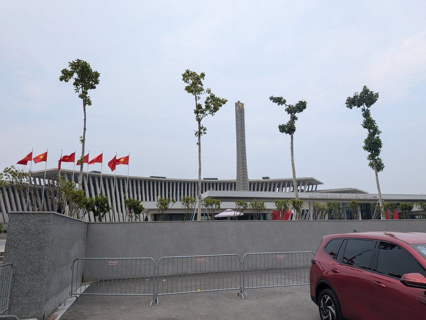 ベトナム軍事歴史博物館の外観。赤い国旗が並ぶ建物と勝利の塔