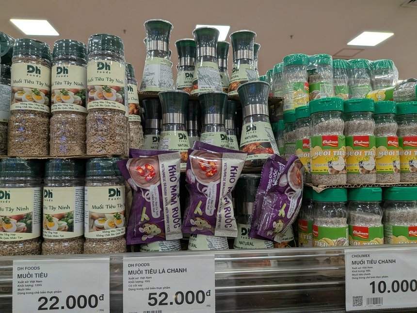 DH FoodsとCholimexの塩コショウの棚。値札はDH Foodsのムオイティウが22,000ドン、ライムの葉入りが52,000ドン、Cholimexのライム塩が10,000ドン