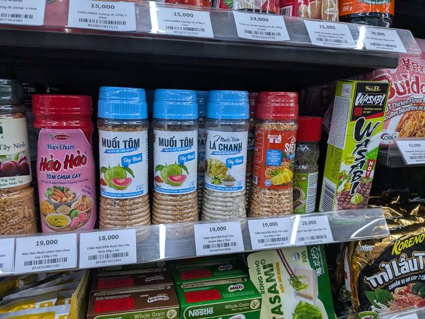 ピンクのハオハオのつけ塩と、タイニン（Tây Ninh）のエビ塩・ライム塩の瓶。値札は18,000〜20,000ドン
