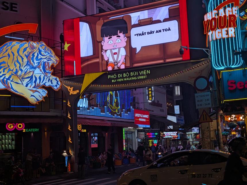 夜のブイビエン通りの入口。「BUI VIEN WALKING STREET」の門とネオンが光る