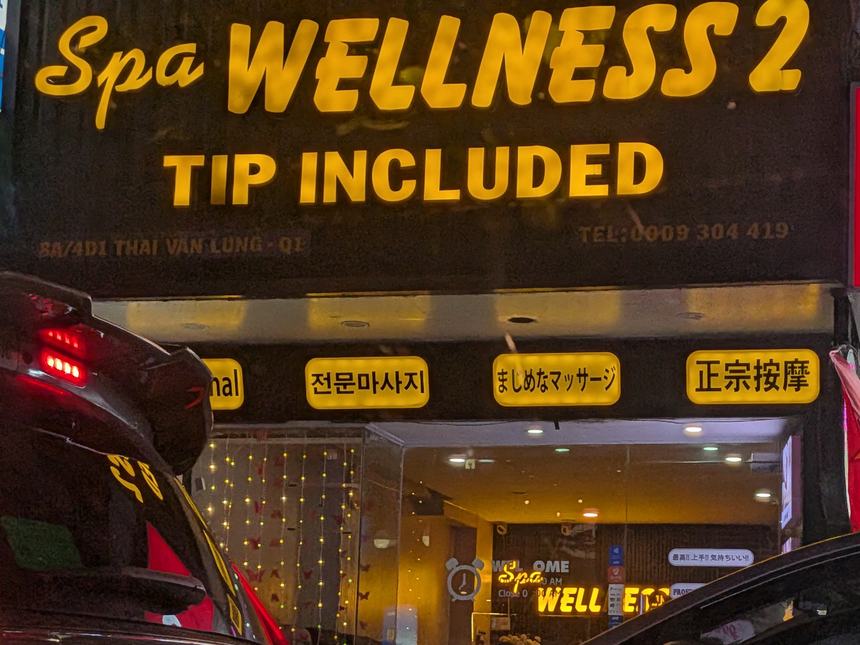 ホーチミンのタイバンルン通りにある Spa WELLNESS 2 の看板。「TIP INCLUDED」と、日本語の「まじめなマッサージ」の表示が出ている